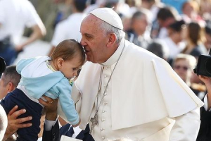 Pope Francis kisses a baby as he arrives to lead the weekly audience in Saint Peter's Square at the Vatican October 7, 2015.  <br/>REUTERS/Tony Gentile