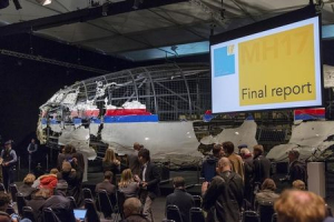The reconstructed airplane serves as a backdrop during the presentation of the final report into the crash of July 2014 of Malaysia Airlines flight MH17 over Ukraine, in Gilze Rijen, the Netherlands, October 13, 2015.  <br/>REUTERS/Michael Kooren