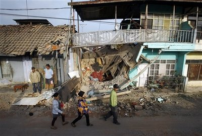 Residents walk past the ruins of houses destroyed by an earthquake in Pengalengan, West Java, Indonesia, Friday, Sept. 4, 2009. Dozens of people were killed and missing after a strong earthquake rocked southern Indonesia Wednesday, unleashing mudslides that buried villagers in their homes, disaster management officials said. <br/>(Photo: AP Images / Achmad Ibrahim)