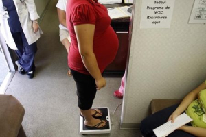 A pregnant woman stands on a scale before receiving a prenatal exam at the Maternity Outreach Mobile in Phoenix, Arizona October 8, 2009. <br/> REUTERS/Joshua Lott