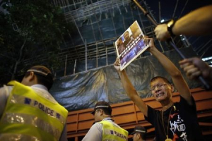 A pro-democracy protester cries as he holds a placard urging an investigation into the alleged police beating of Ken Tsang Kin-chiu, an hospitalized protester, during a rally in front of the police headquarters of Wan Chai district in Hong Kong October 14, 2014.  <br/>REUTERS/Carlos Barria