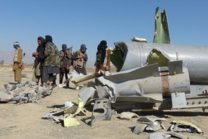 Taliban militants stand next to the wreckage of components jettisoned by a damaged aircraft, which the militants say they had hit, in Sayed Karam district of eastern Paktia province, Afghanistan October 14, 2015.  <br/>REUTERS/Stringer