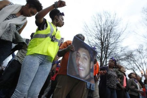 People protest over the police shooting of a man named Anthony Hill as they carry his photo in Decatur, Georgia March 11, 2015. <br/> REUTERS/Tami Chappell