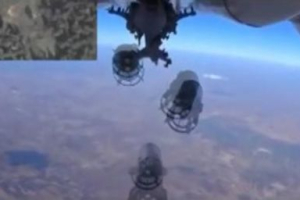 A frame grab taken from footage from a camera under a plane, released by Russia's Defence Ministry October 5, 2015, shows a Russian military jet dropping bombs, as a miniature screen (L top) displays the territory moments before the airstrikes, near Idlib in Syria. <br/> REUTERS/Ministry of Defence of the Russian Federation/Handout via Reuters