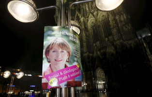 An election campaign poster showing independent candidate Henriette Reker is pictured in front of Cologne's famous Koelner Dom cathedral following the mayoral elections in Cologne, Germany, October 18, 2015.  <br/>REUTERS/Wolfgang Rattay