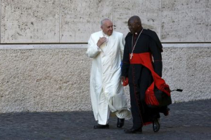 Pope Francis chats with Cardinal Philippe Nakellentuba Ouedraogo (R) as he arrives to lead the synod on the family in the Synod hall at the Vatican, October 23, 2015. <br/>REUTERS/Alessandro Bianchi