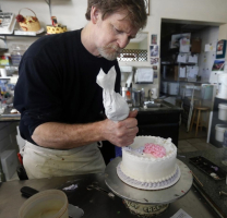 Masterpiece Cakeshop owner Jack Phillips decorates a cake inside his store, in Lakewood, Colo. Colorado's Civil Rights Commission on Friday upheld a judge's ruling that Phillips cannot refuse to make wedding cakes for same-sex couples, despite Phillips' cited religious opposition.  <br/>(AP)