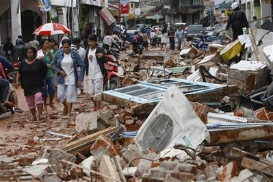 Residents walk through an area damaged earthquake in Padang, West Sumatra, Indonesia, Thursday, Oct. 1, 2009. A second earthquake with a 6.8 magnitude rocked western Indonesia Thursday, a day after the region was devastated by an undersea quake of 7.6 magnitude. <br/>(Photo: AP Images / Dita Alangkara)
