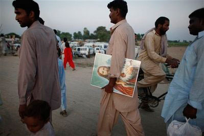 In this photo taken on Saturday, Sept. 5, 2009, a pilgrim carries an image of Jesus Christ during the 60th Christian Festival in the village of Mariamabad, Sheikhupura district, Pakistan. Non-Muslims make up less than 5 percent of Pakistan's 175 million people. They are especially vulnerable to anti-blasphemy laws that carry the death penalty for derogatory remarks or any other action against Islam, the Quran or the Prophet Muhammad. <br/>(Photo: AP / Alexandre Meneghini) In this photo taken on Saturday, Sept. 5, 2009, a pilgrim carries 
