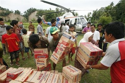 Earthquake survivors carry boxes of food aid distributed by Indonesian Air Police helicopter in Koto Dalam, West Sumatra, Indonesia, Monday, Oct. 5, 2009. Rescue workers called off the search Monday for life under the rubble left by a massive earthquake, focusing instead on bringing aid to survivors in the towns and hills of western Indonesia, despite being hampered by torrential rains. <br/>(Photo: AP Images / Dita Alangkara)