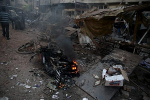 People inspect a site hit by missiles fired by Syrian government forces on a busy marketplace in the Douma neighborhood of Damascus, Syria October 30, 2015. <br/> REUTERS/Bassam Khabieh