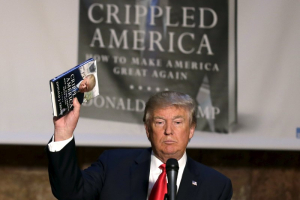 Republican presidential candidate Donald Trump holds up a copy of his new book 