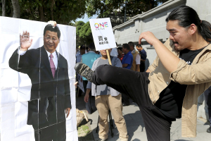 An activist kicks a portrait of Chinese President Xi Jinping during a protest against the upcoming meeting between Taiwan's President Ma Ying-jeou and Chinese President Xi Jinping, in front of the Presidential Office in Taipei, Taiwan, November 5, 2015. <br/>Reuters