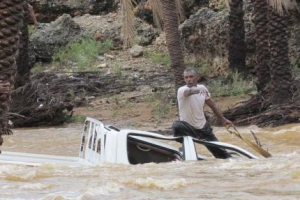 A man gestures as he tries to save a vehicle swept away by flood waters in Yemen's island of Socotra November 2, 2015. <br/> REUTERS/Stringer