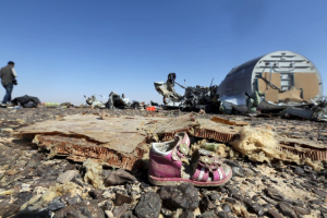 A child's shoe is seen in front of debris from a Russian airliner which crashed at the Hassana area in Arish city, north Egypt, November 1, 2015.  <br/>Reuters