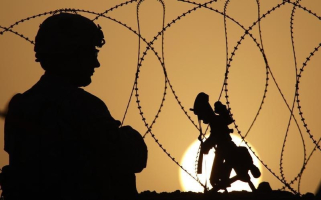 A U.S. Army soldier with the 1-320 Field Artillery Regiment, 101st Airborne Division, keeps watch at sunset from Combat Outpost Terra Nova in the Arghandab Valley north of Kandahar July 18, 2010. <br/>Reuters