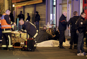 A general view of the scene that shows rescue services personnel working near the covered bodies outside a restaurant following a shooting incident in Paris, November 13, 2015. REUTERS/Philippe Wojazer <br/>
