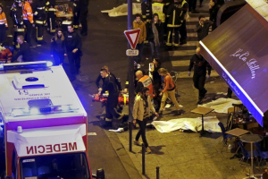 General view of the scene with rescue service personnel working near covered bodies outside the Le Carillon restaurant following shooting incidents in Paris, France, November 13, 2015. <br/>Reuters