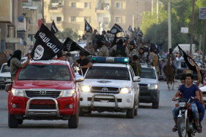 Militant Islamist fighters waving flags, travel in vehicles as they take part in a military parade along the streets of Syria's northern Raqqa province June 30, 2014. <br/>Reuters