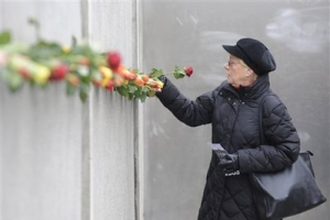 A woman places a rose into part of the former Berlin wall, Monday Nov. 9, 2009, following a commemoration ceremony for the 20th anniversary of the fall of the Berlin Wall on Nov. 9, 1989, at the wall memorial 'Bernauer Strasse' in Berlin, Germany. <br/>(Photo: AP Images / Fabian Bimmer)