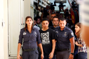 Tariq Khdeir (C), a 15-year-old American of Palestinian descent and a cousin of Mohammed Abu-Khdeir, the youth whom Palestinians believe was abducted and murdered by far-right Israelis on Wednesday, is escorted by Israeli prison guards during an appearance at Jerusalem magistrate's court July 6, 2014.  <br/>Reuters