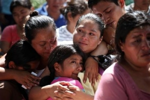 Relatives mourn during the funerals for Catalina Ayala, 80, and Carolina Ayala, 15, who died during flooding in Verapaz, El Salvador, Monday, Nov. 9, 2009. Mud and rock slides caused by rain-fueled floods killed at least 124 people throughout El Salvador and left about five dozen missing, authorities said. <br/>(Photo: AP Images / Rodrigo Abd)