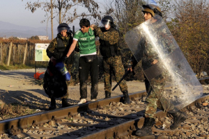 An Iranian migrant is escorted back to Greece by Macedonian policemen after he tried to cross Greece's border with Macedonia illegally, near the Macedonian town of Gevgelija, November 19, 2015. <br/>Reuters