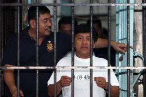 Andal Ampatuan Jr., a town mayor suspected in Monday's massacre, of Unsay township, Maguindanao province in southern Philippines, holds his detainee number while being photographed inside his... <br/>(AP) 
