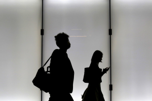 A man and a woman are silhouetted as they walk on an overpass at a business district in Tokyo, Japan, November 5, 2015.  <br/>REUTERS/Yuya Shino