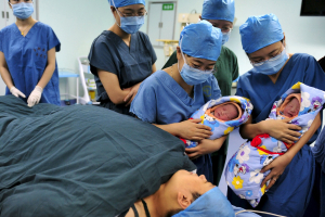 Nurses show a pair of fraternal twins to their mother (bottom) after they were born at the IVF centre of a hospital in Xi'an, Shaanxi province in this August 16, 2012 file picture. <br/>Reuters