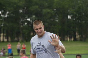 Rob Gronkowski, New England Patriots tight end, high-fives his team during a football camp on Joint Base Andrews, Md., July 2, 2015. Gronkowski, a three time Pro Bowler and Super Bowl XLIX champion, coached approximately 100 military children during the two-day camp. <br/>Wikimedia Commons/U.S. Air Force photo/Tech. Sgt. Robert Cloys