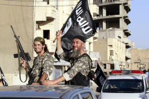 <br />
Militant Islamist fighters wave flags as they take part in a military parade along the streets of Syria's northern Raqqa province June 30, 2014.  <br/>Reuters
