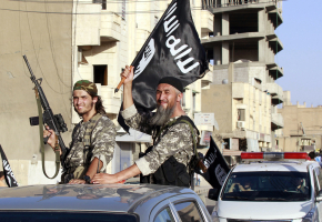 Militant Islamist fighters wave flags as they take part in a military parade along the streets of Syria's northern Raqqa province June 30, 2014.  <br/>Reuters