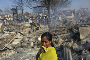 A woman cries as she stands on debris from her gutted hut after a fire occurred in a slum area in Mumbai, India, December 7, 2015. REUTERS/Danish Siddiqui <br/>