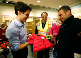 Syrian refugees are presented with a child's winter jacket by Canada's Prime Minister Justin Trudeau (L) on their arrival from Beirut at the Toronto Pearson International Airport in Mississauga, Ontario, Canada December 11, 2015. REUTERS/Mark Blinch <br/>