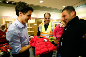 Syrian refugees are presented with a child's winter jacket by Canada's Prime Minister Justin Trudeau (L) on their arrival from Beirut at the Toronto Pearson International Airport in Mississauga, Ontario, Canada December 11, 2015. REUTERS/Mark Blinch <br/>