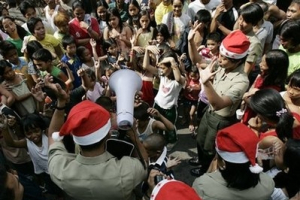 Members of the Philippine Armed Forces hold a dance contest with victims of a recent fire in suburban Pasay city, south of Manila, Philippines on Christmas day Friday Dec. 25, 2009. Many residents celebrated the day inside tents and evacuation sites as fire gutted hundreds of shanties two days before Christmas leaving thousands homeless. <br/>AP Photo/ Aaron Favila