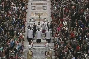 In this image made from Vatican television via APTN, Vatican security, at center of aisle in black, make their way towards Pope Benedict XVI, not seen, after he was knocked down during Christmas Mass in St. Peter's Basilica at the Vatican, Thursday, Dec. 24, 2009. A woman jumped the barriers in St. Peter's Basilica and knocked down the pontiff as he walked down the main aisle to begin Christmas Eve Mass on Thursday, a Vatican spokesman said. The Rev. Ciro Benedettini said the 82-year-old pope quickly got up and was unhurt. <br/>APTN