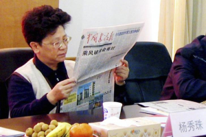 Yang Xiuzhu reads a newspaper during a meeting in Wenzhou, Zhejiang province, December 29, 2001.  <br/>Reuters