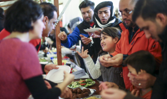 Migrants receive food at a Christmas market in a refugee shelter run by German charity organisation Arbeiter Samariter Bund ASB in Berlin, Germany, December 12, 2015.  <br/>Reuters