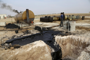 Men work at a makeshift oil refinery site in Marchmarin town, southern countryside of Idlib, Syria in this December 16, 2015, file photo.  <br/>REUTERS/Khalil Ashawi