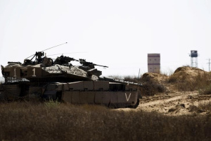 An Israeli army tank takes position along Israel's border with Egypt's North Sinai (seen in background) July 1, 2015. Islamic State militants launched a wide-scale coordinated assault on several military checkpoints in Egypt's North Sinai on Wednesday in which 50 people were killed, security sources said, the largest attack yet in the insurgency-hit province. Egyptian army F-16 jets and Apache helicopters strafed the region that lies within the Sinai Peninsula, a strategic area located between Israel, the Gaza Strip and the Suez Canal. <br/>Reuters