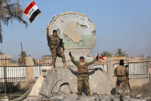 A member of the Iraqi security forces holds an Iraqi flag at a government complex in the city of Ramadi, December 28, 2015. <br/>Reuters
