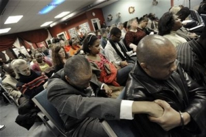 Gerald Duval, right, holds hands with alderman and chairman of Haitian Congress to Fortify Haiti Lionel Jean-Baptiste, left, during a service for Haiti at The New Hope Haitian Church in Evanston, Ill., Sunday, Jan. 17, 2010. <br/>AP Photo / Paul Beaty