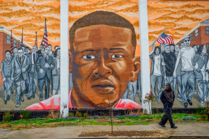 A man, who declined to offer his name, walks past a mural of Freddie Gray in the Sandtown-Winchester neighborhood of Baltimore, December 17, 2015.  <br/>Reuters