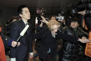 American missionary Robert Park, left, is escorted by a U.S. official as he is surrounded by journalists upon his arrival at the Beijing Capital Airport, Saturday, Feb. 6, 2010. His arrival in Beijing came a day after North Korea announced it would free Robert Park <br/>AP/Andy Wong