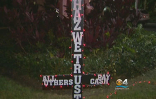 An upside down cross that lights up in red as a symbol for ''Satanology'' sits outside Hallandale Beach City Hall, Florida. CBS Miami <br/>