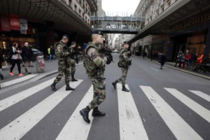 French soldiers patrol in the street near a department store in Paris as part of the highest level of 