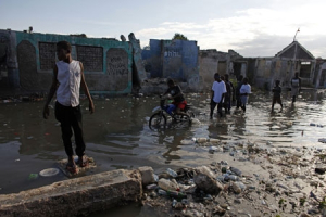 People walk in flooded streets in the Cite Soleil neighborhood of Port-au-Prince, Thursday, Feb. 18, 2010. Heavy rains overnight flooded parts of the capital city as it recovers from the damage caused by the Jan. 12 earthquake. <br/>AP Images / Javier Galeano