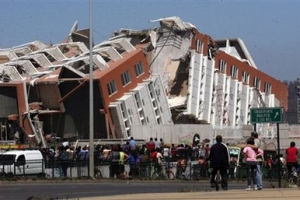 Residents look at a collapsed building in Concepcion, Chile, Saturday Feb. 27, 2010 after an 8.8-magnitude struck central Chile. The epicenter was 70 miles (115 kilometers) from Concepcion, Chile's second-largest city. <br/>AP Images